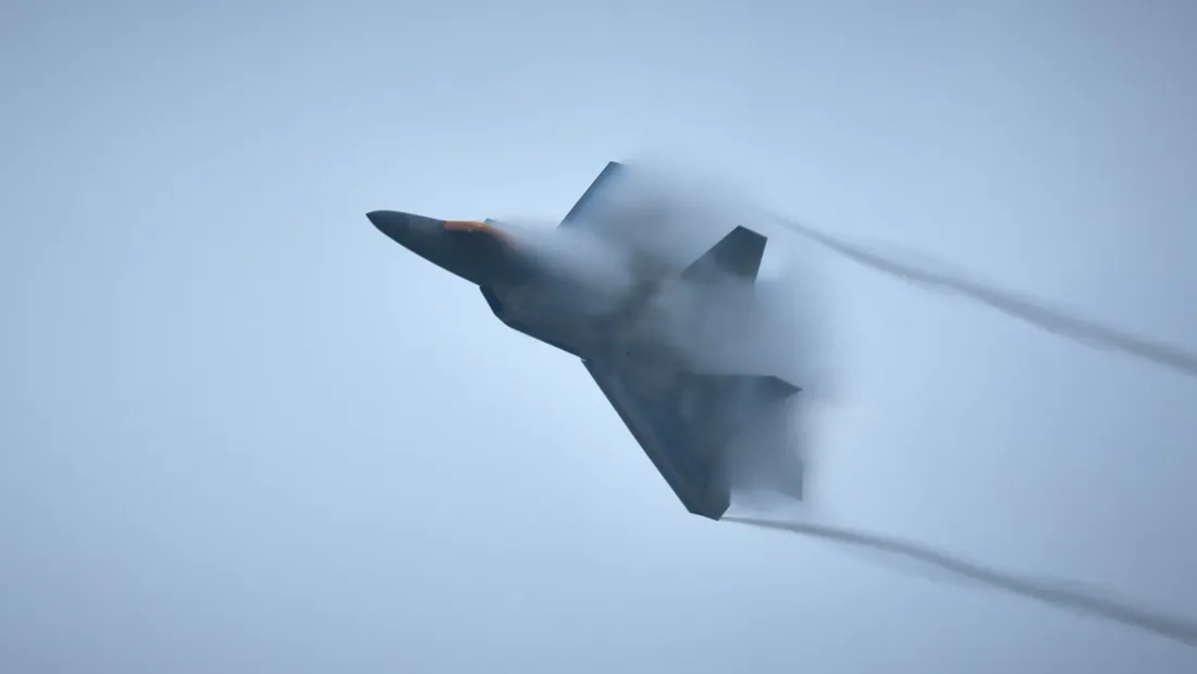A fighter jet emerging from cloud